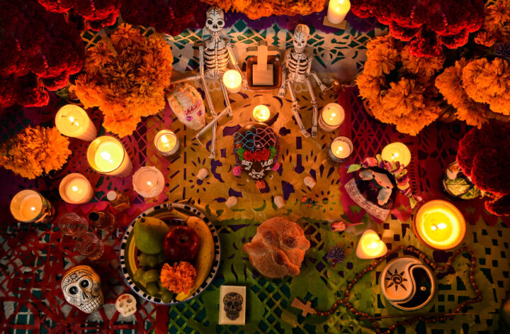 Mexican day of the dead altar at night in dim candlelight